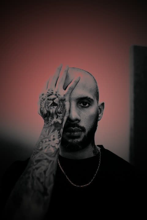 BE SKILLZ con la mano tatuada sobre la cara